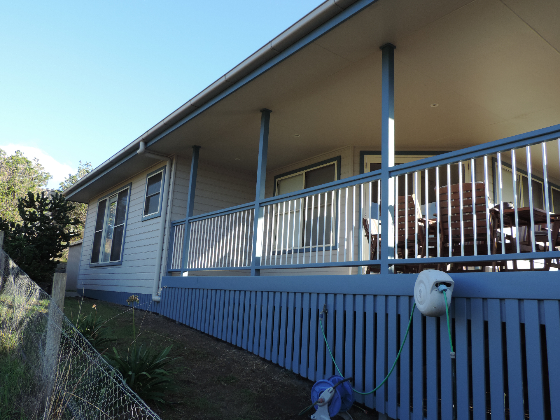 Exterior house repaint with blue railings and posts