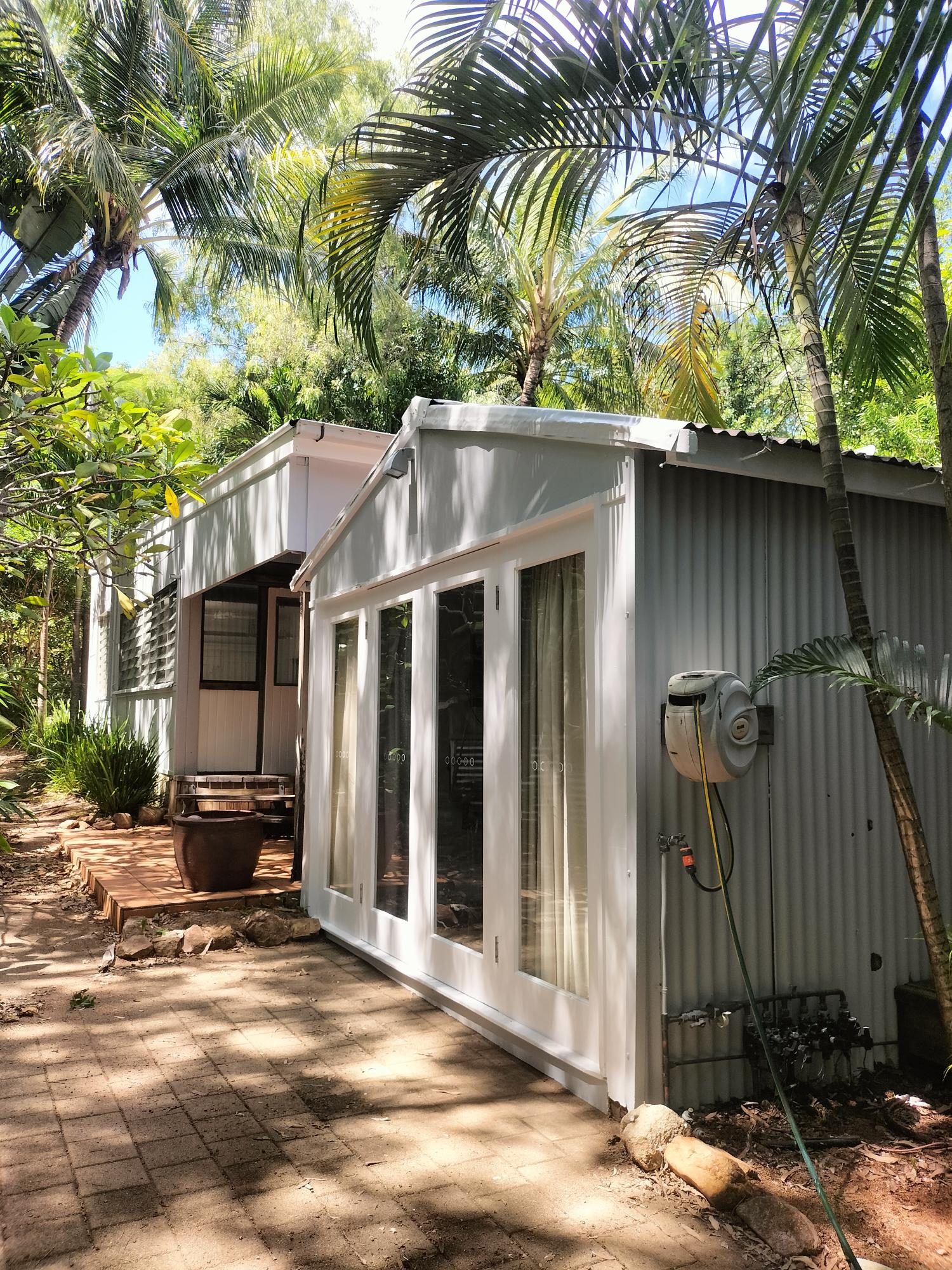 Repainted exterior cottage nestled among tropical palms